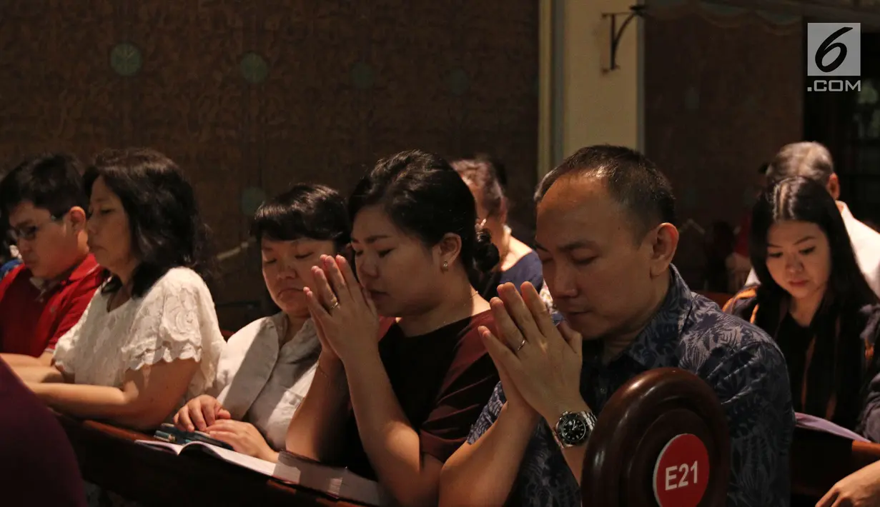 Umat Nasrani terlihat khusyuk berdoa saat mengikuti Misa Natal di Gereja Katedral, Jakarta, Minggu (24/12). Dalam perayaan Natal ini dekorasi di area Gereja Katedral juga disesuaikan dengan tema tersebut. (Liputan6.com/Herman Zakharia)