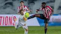 Gelandang Real Madrid, Luka Modric, berebut bola dengan pemain Athletic Bilbao, Inaki Williams, pada laga Liga Spanyol di Stadion Alfredo Di Stefano, Rabu (16/12/2020). Real Madrid menang dengan skor 3-1. (AP/Bernat Armangue)