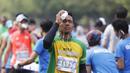 Seorang pelari mengguyur wajahnya dengan air saat mengikuti Mandiri Jakarta Marathon. (Bola.com/Vitalis Yogi Trisna)