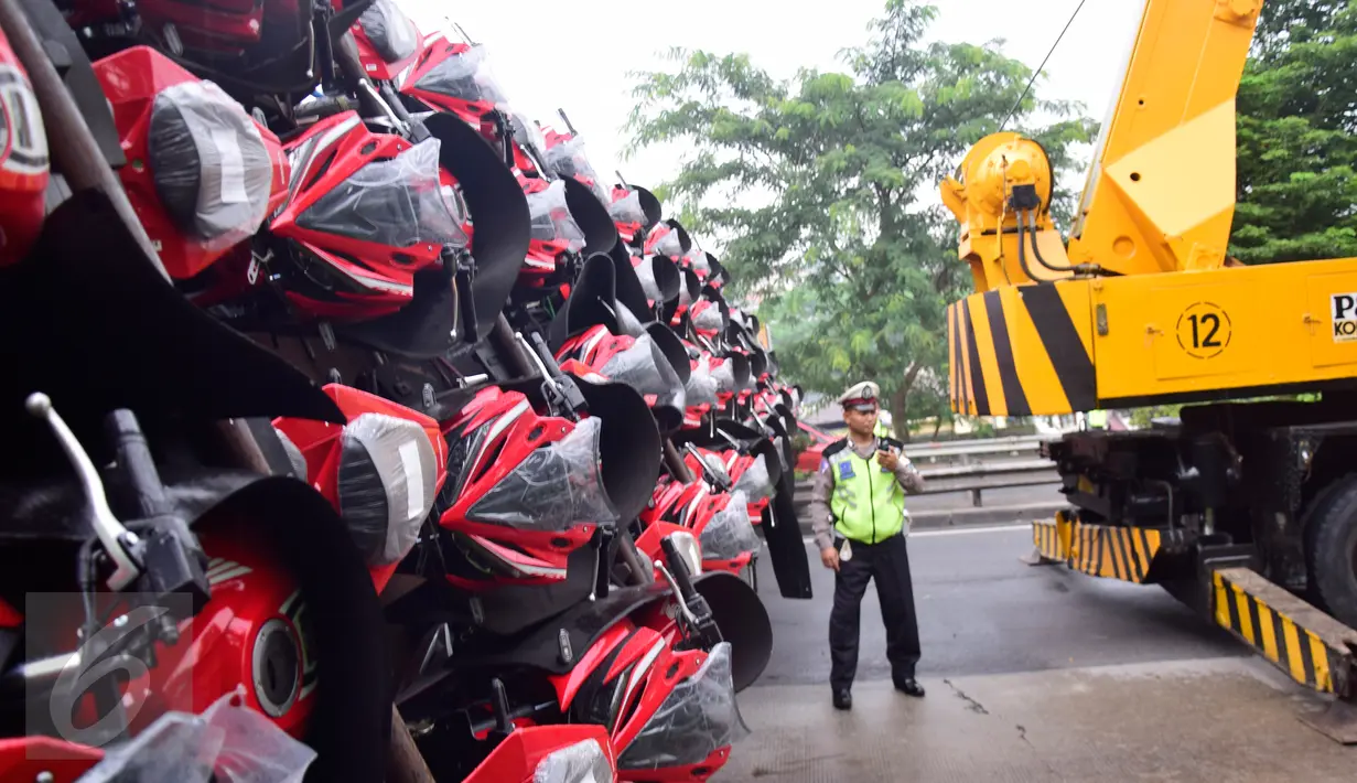 Sebuah crane didatangkan untuk membantu truk yang terguling di Ruas Tol  KM 10 Kota Semarang, Jawa Tengah, Senin (6/3). (Liputan6.com/Gholib)