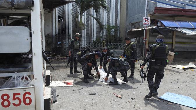 Polisi mengevakuasi kantong jenazah pasca ledakan bom di Gereja Katolik Jolo, Filipina Selatan, Minggu (27/1).  (Nickee Butlangan/AFP)
