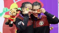 Pesilat Indonesia Riska Hermawan (kiri) dan Ririn Rinasih menunjukkan medali emas usai menjuarai nomor Seni Ganda Wanita Pencak Silat Sea Games 2021 Vietnam di Bac tu Liem Sport Center, Hanoi, Rabu (11/5/2022). (Bola.com/Ikhwan Yanuar)
