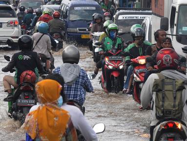 Pengendara melewati banjir yang menggenangi kawasan perempatan Mampang, Depok, Jawa Barat, Rabu (18/05/20222). Banjir tersebut disebabkan meluapnya Kali Mampang. Menurut pejabat setempat, banjir terjadi akibat adanya batang pohon yang tersangkut di kolong jembatan Mampang. (merdeka.com/Arie Basuki)