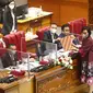 Pimpinan DPR menerima berkas tanggapan pemerintah dari Menteri Keuangan Sri Mulyani (kanan) saat rapat paripurna DPR Ke-10 masa Persidangan II Tahun Sidang 2021-2022 di Kompleks Parlemen, Senayan, Jakarta, Selasa (7/12/2021). (Liputan6.com/Angga Yuniar)