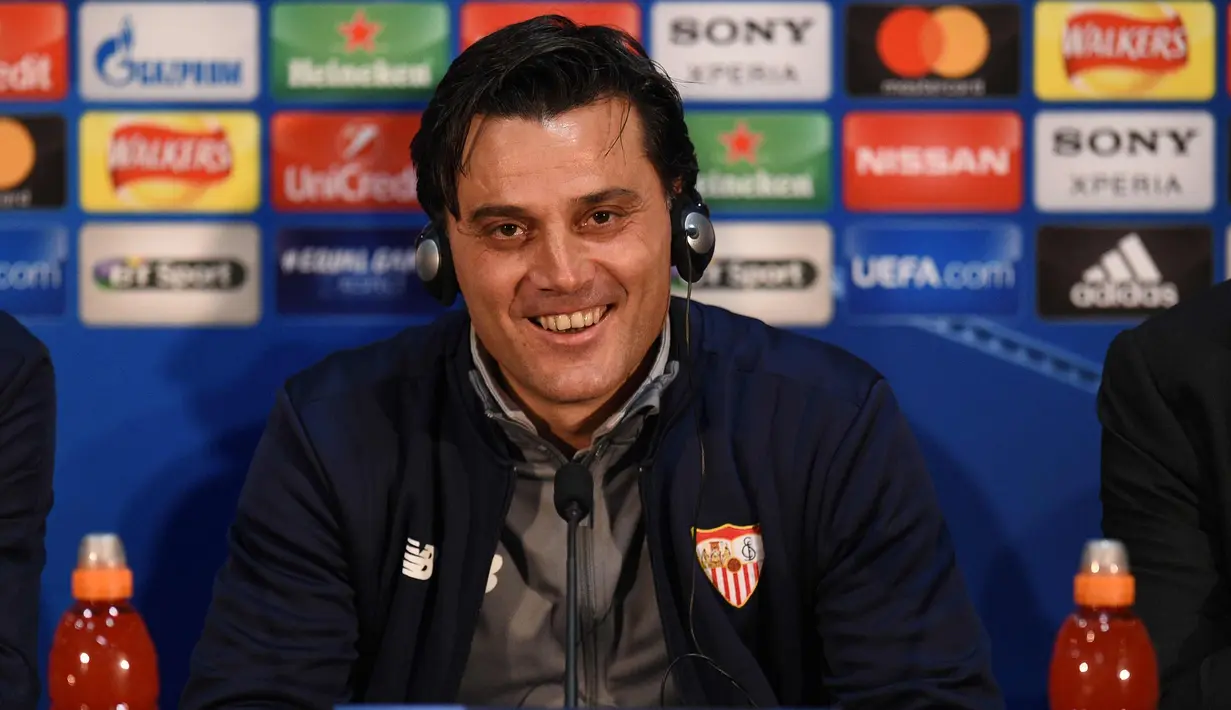 Pelatih Sevilla, Vincenzo Montella tersenyum saat konferensi pers di stadion Old Trafford di Manchester, Inggris (12/3). Sevilla akan melawan Manchester United pada leg kedua babak 16 besar Liga Champions. (AFP Photo/Oli Scarff)