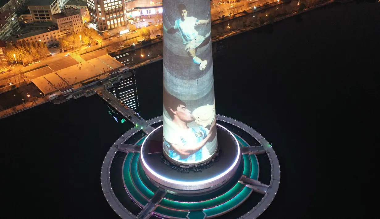 Foto dari udara menunjukkan gambar legenda sepak bola Diego Maradona yang diproyeksikan di Menara TV Tianjin di Kota Tianjin, China utara (26/11/2020). Maradona tutup usia di usia 60 tahun akibat serangan jantung pada Rabu (25/11). (Xinhua/Li Ran)