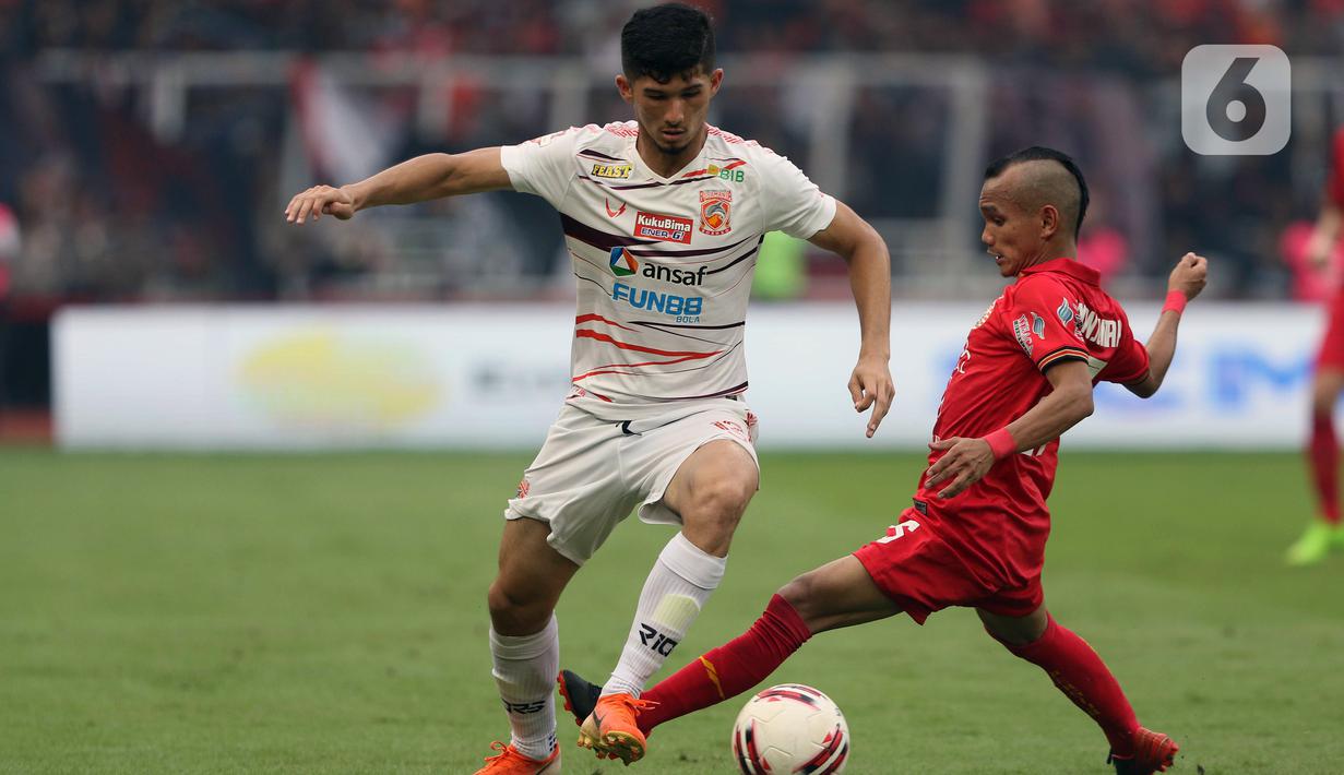 Gelandang Persija, Riko Simanjuntak (kanan) mencoba menahan pergerakan pemain belakang Borneo FC, Kevin Gomes De Oliveira pada laga pekan pertama Shopee Liga 1 Indonesia 2020 di Stadion Gelora Bung Karno, Jakarta, Minggu (1/3/2020). Persija unggul 3-2. (Liputan6.com/Helmi Fithriansyah)