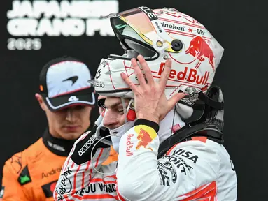 Pembalap Red Bull Racing asal Belanda, Max Verstappen (kanan) melepas helmnya setelah kemenangannya pada Fomula 1 Grand Prix Jepang di sirkuit Suzuka, prefektur Mie, Jepang pada 6 April 2025. (Toshifumi KITAMURA/AFP)