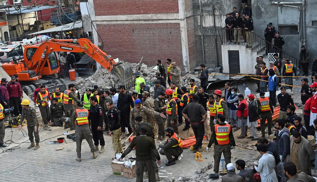 Petugas penyelamat membawa korban ledakan dari puing-puing masjid yang rusak setelah ledakan di dalam markas besar polisi di Peshawar, Pakistan, Senin (30/1/2023). Kepala polisi Peshawar, Muhammad Ijaz Khan, mengatakan kepada media lokal bahwa antara 300 hingga 400 petugas polisi berada di daerah tersebut pada saat ledakan terjadi. (Abdul MAJEED/AFP)