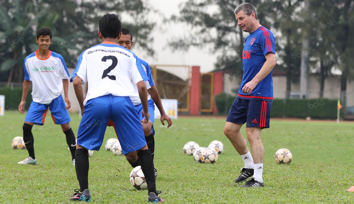 Legenda Manchester United, Denis Irwin (kanan), melakukan pemanasan sebelum bertanding pada acara United Way Coaching Clinic You C 1000 di Stadion Soemantri Brojonegoro, Jakarta, Sabtu (7/5/2016). (Bola.com/Nicklas Hanoatubun)
