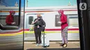Petugas memberikan salam kepada penumpang yang akan menaiki KA Taksaka di Stasiun Gambir, Jakarta, Sabtu (4/8/2021). Dalam rangka memperingati hari pelanggan nasional, PT KAI Daop 1 Jakarta membagikan ratusan bingkisan kepada penumpang kereta api. (Liputan6.com/Faizal Fanani)