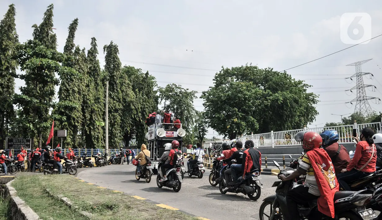 Massa dari berbagai serikat buruh menggelar aksi menolak UU Omnibus Law Cipta Kerja di kawasan JIEP, Jakarta, Selasa (6/10/2020). Ratusan buruh berpawai sambil berorasi mengajak pekerja turun ke jalan menolak UU Omnibus Lawa Cipta Kerja yang dinilai merugikan buruh. (merdeka.com/Iqbal S. Nugroho)