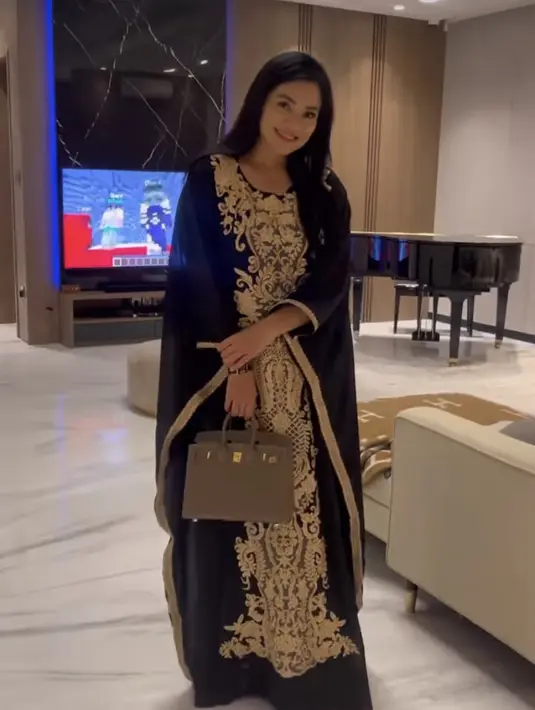 Ibu dua anak ini juga tampil mengenakan abaya hitam yang memiliki detail bordiran keeamasan. Credit: Instagram  (@titi_kamall)
