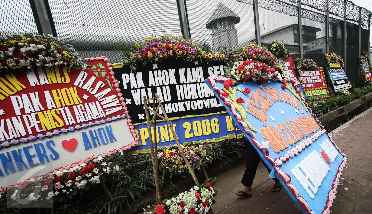 Pekerja membawa karangan bunga pesanan dari pendukung Basuki Tjahaja Purnama atau Ahok di depan Rutan Cipinang, Jakarta, Rabu (10/5). Karangan bunga terus berdatangan, meski Ahok sudah dipindahkan ke Rutan Mako Brimob, Depok. (Liputan6.com/Faizal Fanani)