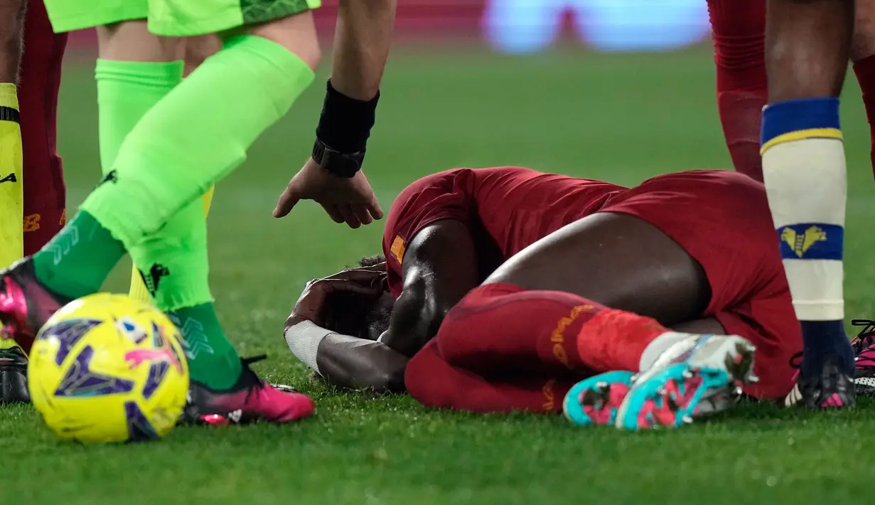Pemain AS Roma Tammy Abraham terbaring di lapangan setelah cedera saat melawan Verona pada pertandingan sepak bola Liga Italia di Stadion Olimpiade Roma, Italia, 19 Februari 2023. AS Roma mengalahkan Verona dengan skor 1-0. (AP Photo/Andrew Medichini)