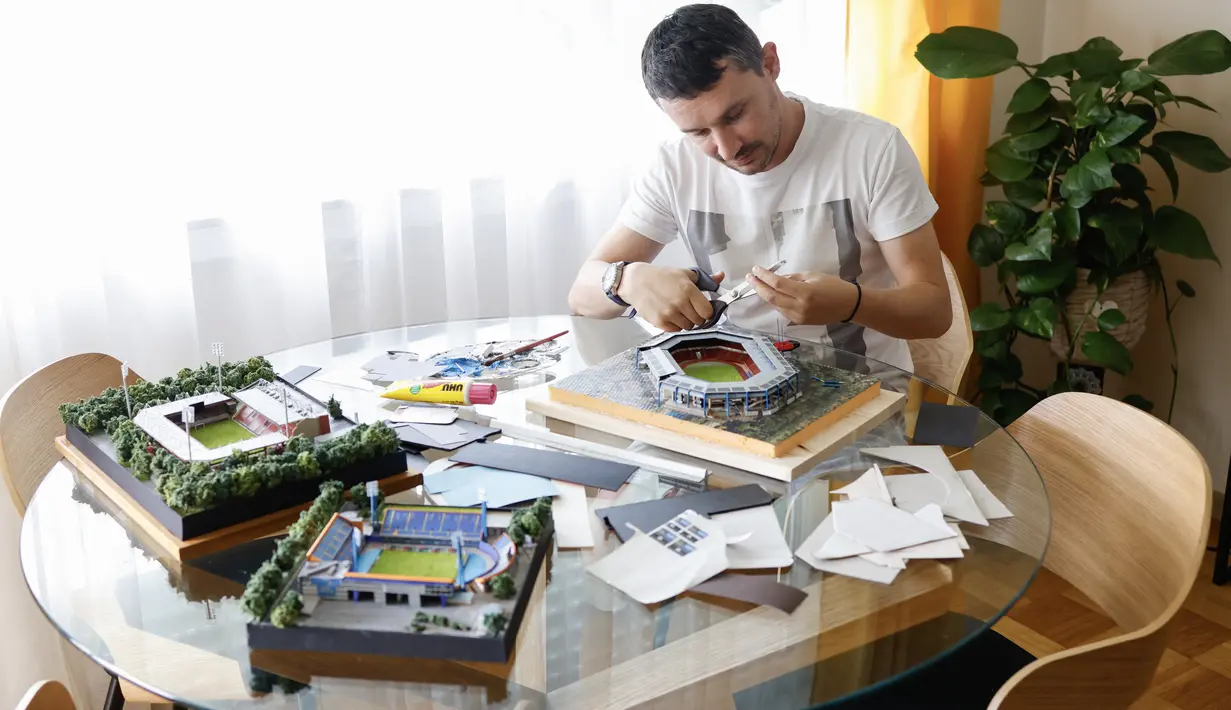 Josip Marsic (35) asal Kroasia, pada 8 Juli 2024 mengerjakan miniatur stadion sepak bola Max Morlock di Nuremberg, yang dibangun sendiri di apartemennya di Munich dari kertas karton, berbagai bahan kemasan, kabel, sebagai hobi. (Michaela STACHE / AFP)