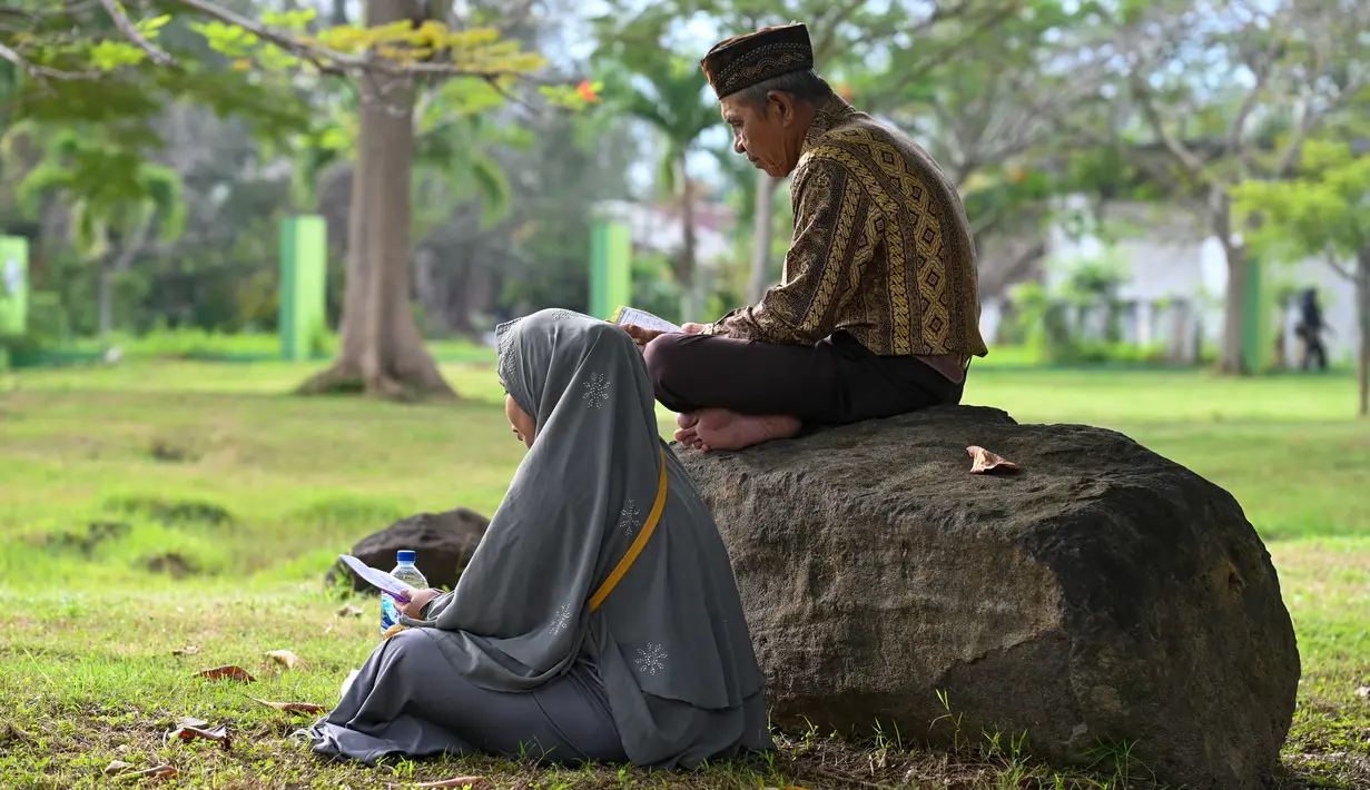 <p>Orang-orang berdoa saat memperingati 18 tahun musibah gempa dan tsunami di kuburan massal Siron, Aceh, Senin (26/12/2022). Sejumlah warga mendatangi Kuburan Massal Siron untuk memenjatkan doa saat peringatan 18 tahun musibah gempa dan tsunami Aceh 2004. (AFP/Chaideer Mahyuddin)</p>