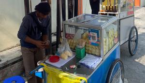 Rizki Anggoro saat berjualan gerobak buah bernama Buah Segar Lotis AA Kutudukuh di kawasan Kutu Tegal, Kab. Sleman, Yogyakarta. Ia berhasil naik kelas lewat QRIS BRI. (Foto: Liputan6/Fardi Rizal)