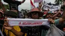 Nelayan membentangkan kain pengikat kepala dalam unjuk rasa menolak larangan penggunaan cantrang di depan Istana Negara, Jakarta Pusat, Rabu (17/1). Nelayan mendesak pencabutan Peraturan Menteri Nomor 2/2015 tentang cantrang. (Liputan6.com/Faizal Fanani)