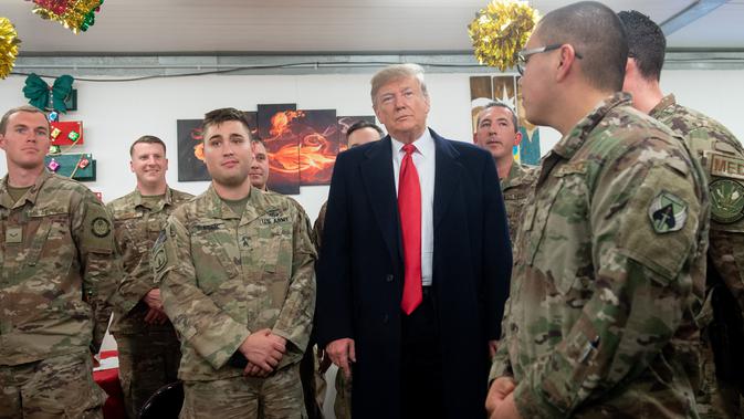 Presiden Donald Trump menyapa pasukan militer Amerika dalam kunjungan kejutan ke Pangkalan Udara al Asad, Irak, Rabu (26/12). Kunjungan ini merupakan kunjungan perdananya setelah mengumumkan penarikan pasukan militer dari Suriah. (SAUL LOEB/AFP)