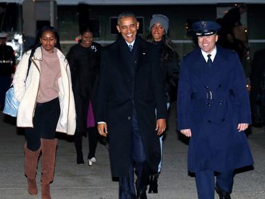 Presiden Barack Obama dan keluarga berjalan menuju pesawat Air Force One di Joint Base Andrews di Maryland, AS (16/12). Obama akan berlibur ke Hawaii untuk merayakan Natal disana. (REUTERS / Kevin Lamarque)