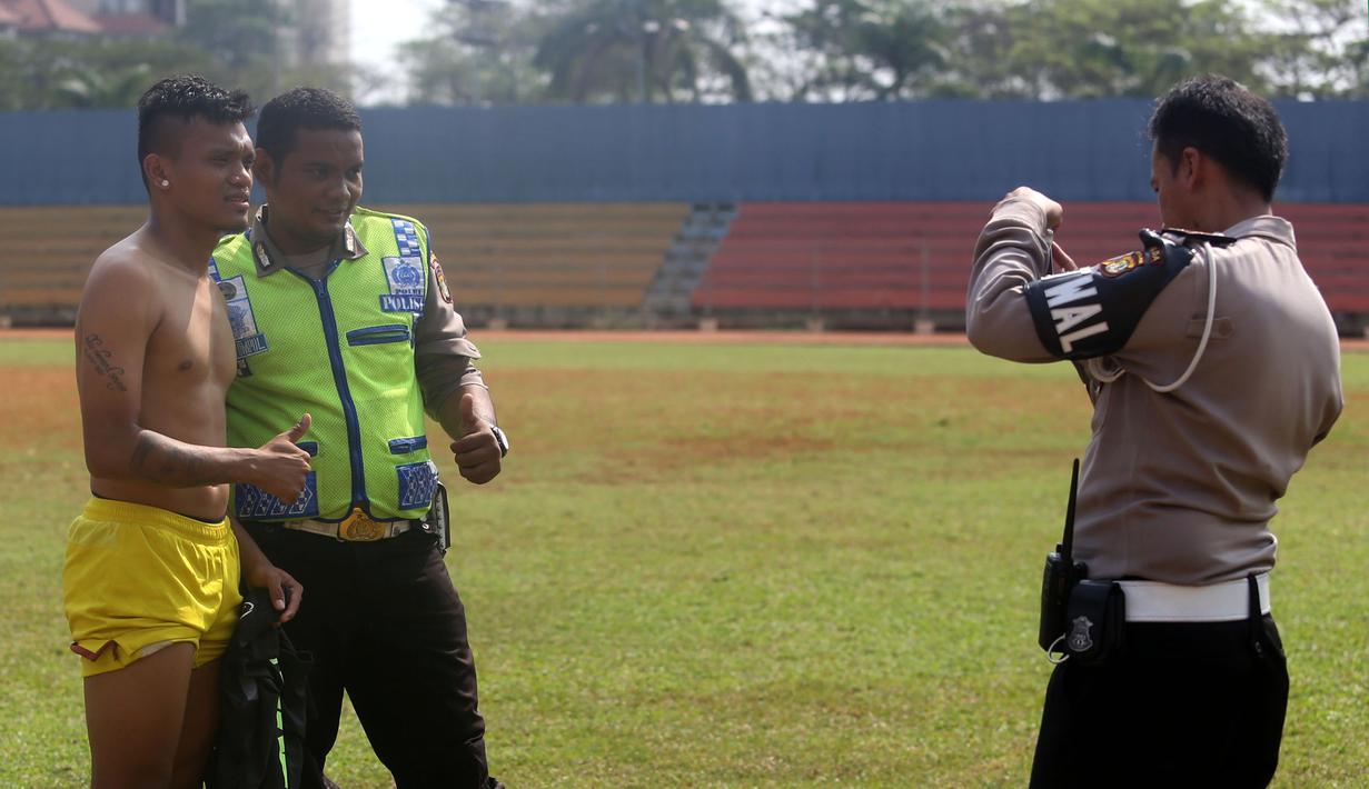 Polisi pun menggunakan kesempatan berfoto dengan Ferdinand Sinaga seusai latihan Sriwijaya FC di Stadion Soemantri Brojonegoro, Jakarta, Jumat (16/10/2015) pagi WIB. (Bola.com/Nicklas Hanoatubun)