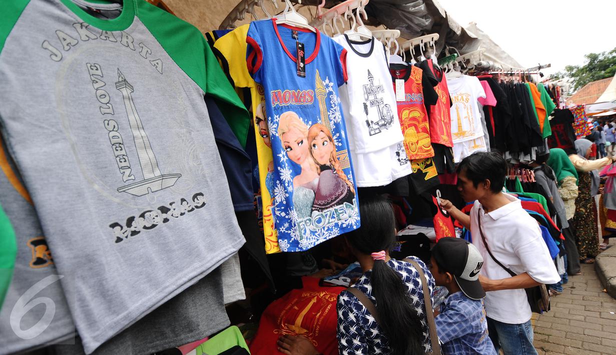 Beberapa warga berburu kaos souvenir di kawasan Monumen Nasional, Jakarta, Minggu (25/12). Libur perayaan Natal 2016 dimanfaatkan sejumlah warga untuk berwisata di kawasan Monumen Nasional. (Liputan6.com/Helmi Fithriansyah)