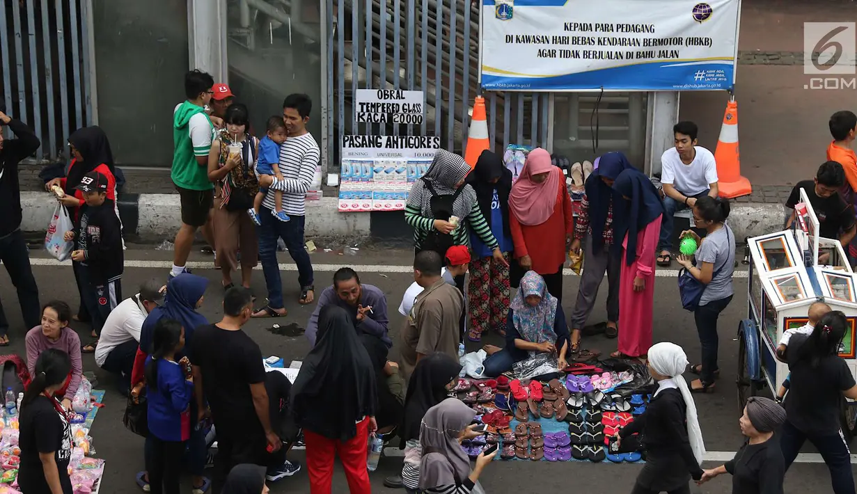 Pengunjung memilih barang saat pelaksanaan car free day di sepanjang Jalan Sudirman, Jakarta, Minggu (1/7). Kurangnya pengawasan menyebabkan banyak PKL yang berjualan tidak pada tempatnya dan memenuhi area CFD. (Liputan6.com/Immanuel Antonius)