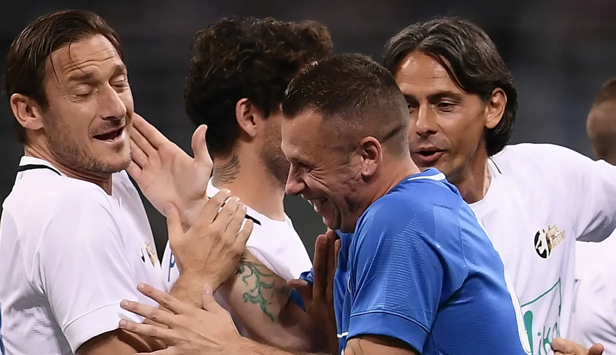 Mantan pemain Timnas Italia, Francesco Totti bercanda dengan Antonio Cassano pada laga Notte del Maestro di Stadion Giuseppe Meazza, Milan, Senin (21/5/2018). Laga ini merupakan seremoni gantung sepatu dari Andrea Pirlo. (AFP/Marco Bertorello)