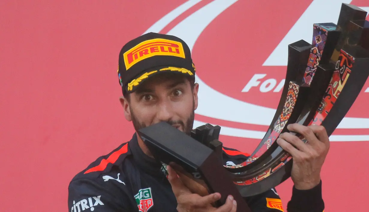 Pembalap Red Bull, Daniel Ricciardo berpose dengan trofi usai memenangkan balapan GP Azerbaijan di Sirkuit Baku City, Minggu (25/6). Ricciardo yang memulai dari posisi 10 mencatatkan waktu 1 jam 41 menit untuk melahap 51 putaran. (AP Photo/Efrem Lukatsky)