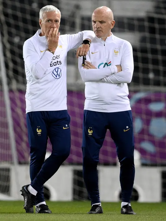 Pelatih Prancis, Didier Deschamps (kiri) berbicara dengan asisten pelatih Guy Stephan selama sesi latihan di Stadion Jassim-bin-Hamad di Doha, 12 Desember 2022. Prancis akan bermain melawan Maroko dalam pertandingan semifinal Piala Dunia 2022 di Stadion Al Bayt, Al Khor, Kamis (15/12/2022) pukul 02.00 WIB. (AFP/Franck Fife)