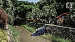 Petugas Dinas Perhubungan Kota Bekasi saat evakuasi mobil yang terperosok ke kali di Harapan Indah, Bekasi, Jawa Barat, Rabu (16/2/2022). Mobil jenis Avanza tersebut jatuh ke dalam kali usai mengalami kecelakaan tunggal akibat tergelincir saat melintasi tikungan. (merdeka.com/Iqbal S. Nugroho)