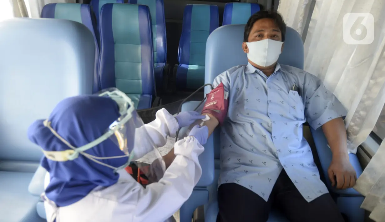 Petugas Palang Merah Indonesia (PMI) mengambil darah pendonor di mobil donor darah keliling, Tangerang Selatan, Banten, Jumat (17/7/2020). PMI mengintensifkan pengoperasian mobil donor darah keliling untuk memenuhi persediaan stok darah saat pandemi COVID-19. (merdeka.com/Dwi Narwoko)