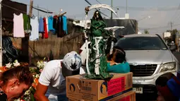 Patung Santa Muerte dipajang warga saat merayakan tahun baru di Meksiko, Minggu (1/1/2017). Warga Meksiko percaya jika berdoa kepada Santa Muerte akan membawa keberuntungan. (REUTERS/Carlos Jasso)