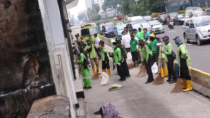 Sejumlah petugas membersihkan puing Halte Bus TransJakarta Tosari yang dirusak saat kericuhan unjuk rasa menolak pengesahan UU Cipta Kerja di Jakarta, Jumat (9/10/2020). Sejumlah fasilitas umum rusak dalam kericuhan yang terjadi Kamis (8/10). (Liputan6.com/Angga Yuniar)