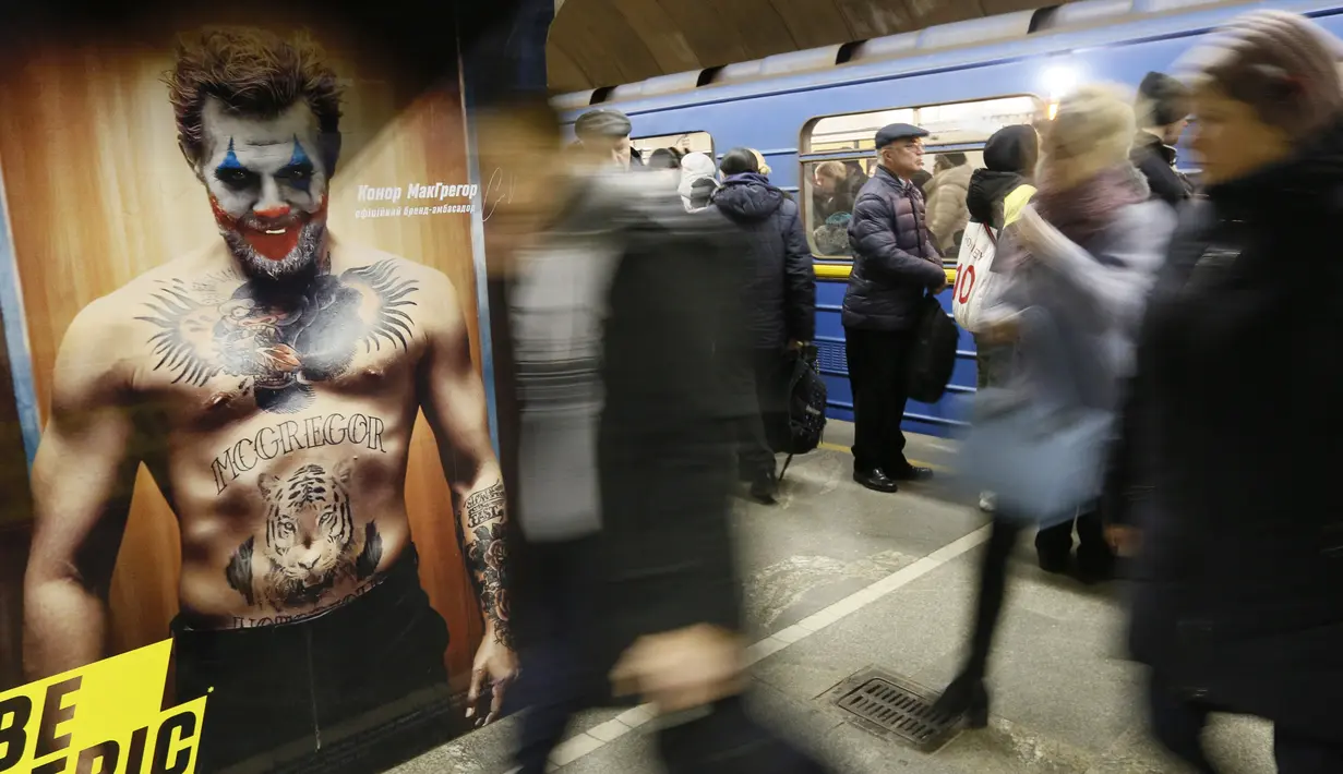Sejumlah penumpang bersiap menaiki kereta di stasiun metro bawah tanah kota  yang dipenuhi dengan mural di Kyiv, Ukraina, Rabu, (29/1/2020). (AP Photo / Efrem Lukatsky)