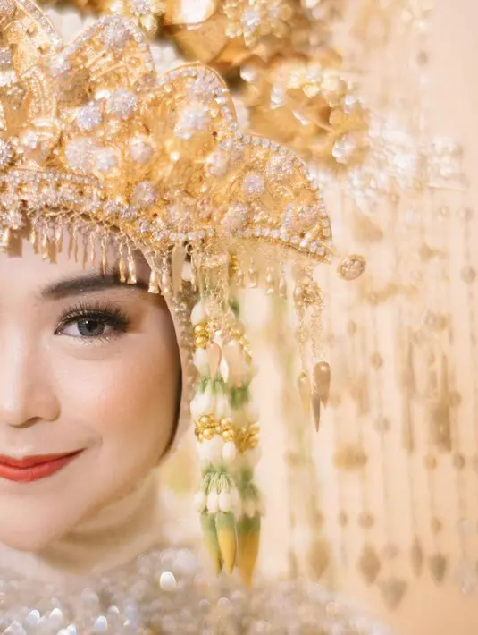 Riasan wajah Ria memancarkan kesan karismatik. Ia memilih bentuk bulu mata yang tegas, dengan eyeshadow keemasan pada kelopak matanya. (Instagram/imagenic)