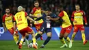 Pemain Paris Saint-Germain, Kylian Mbappe (tengah) berusaha melewati pemain RC Lens pada laga lanjutan Liga Prancis 2022/2023 di the Parc des Princes, Paris, Prancis 15 April 2023. (AFP/Anne-Christine Poujoulat)