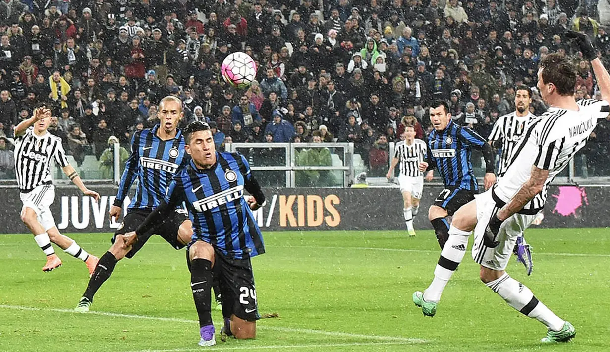 Bomber Juventus, Mario Mandzukic, berusaha membobol gawang Inter Milan. Kemenangan ini membuat Juve kian kokoh di puncak klasemen Serie A. (EPA/Andrea Di Marco)