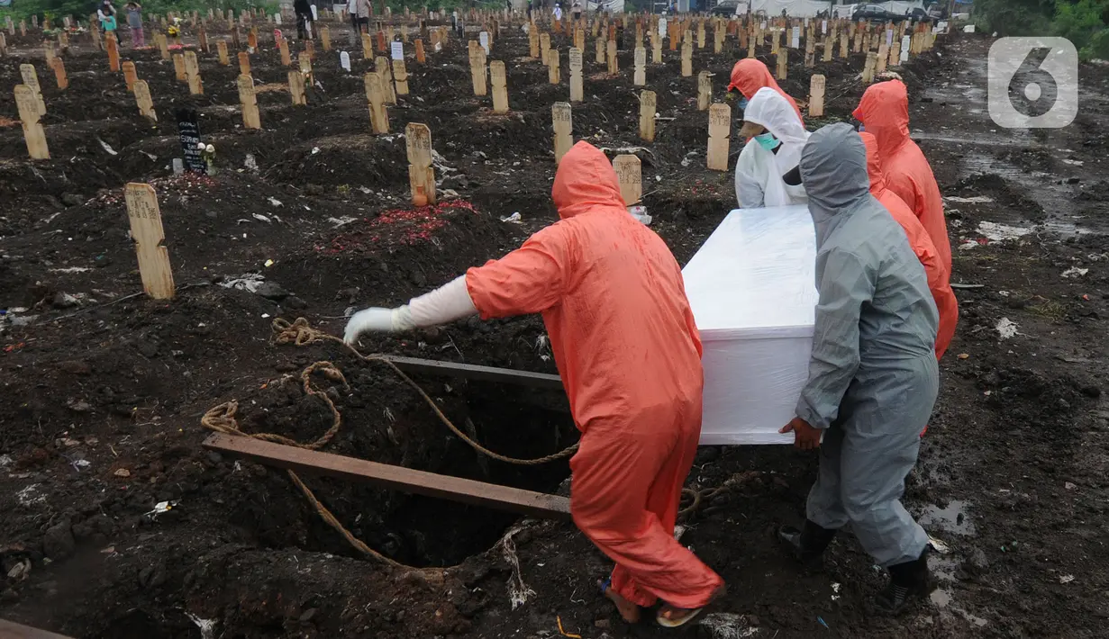 Petugas memakamkan jenazah Covid-19 di TPU Srengseng Sawah 2, Jakarta Selatan, Jumat (19/3/2021). Seminggu terakhir intensitas pemakaman korban covid-19 menurun drastis sebesar rata-rata 20 jenasah/minggu dibandingkan sebelumnya rata-rata 35 jenasah/minggu. (merdeka.com/Arie Basuki)