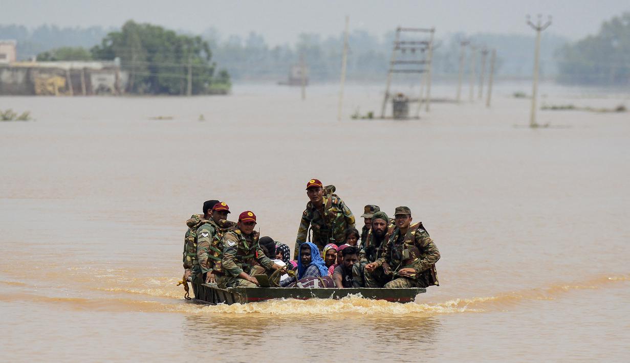 Personil tentara India menyelamatkan penduduk desa dari daerah yang terkena banjir setelah Sungai Sutlej meluap setelah hujan lebat, sekitar 60 Km dari Jalandhar pada 12 Juli 2023. (AFP/Shammi Mehra)