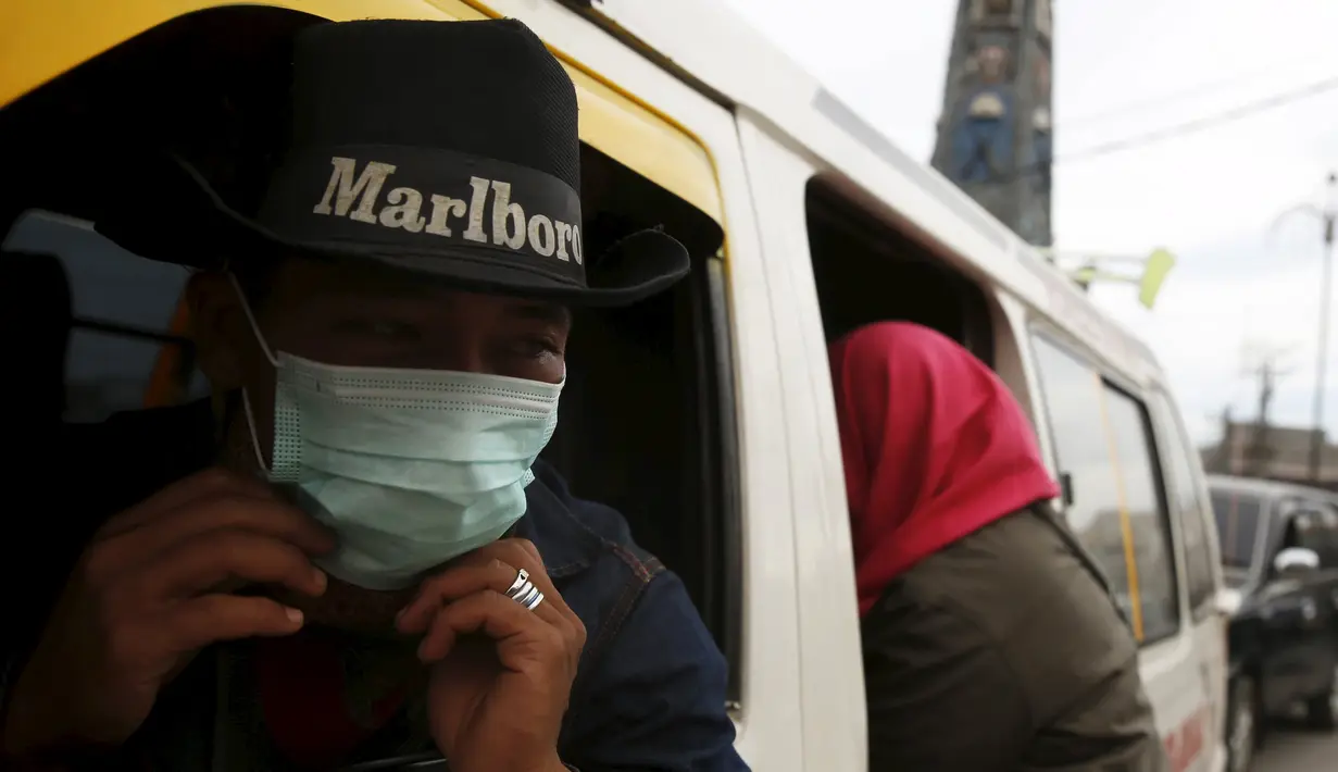 Warga menggunakan masker saat beraktivitas di kawasan Berastagi, Karo, Sumatera Utara, 25 Juni 2015. Debu vulkanik akibat erupsi Gunung Sinabung masih menutupi sebagian Kota Berastagi. (REUTERS/Beawiharta) 