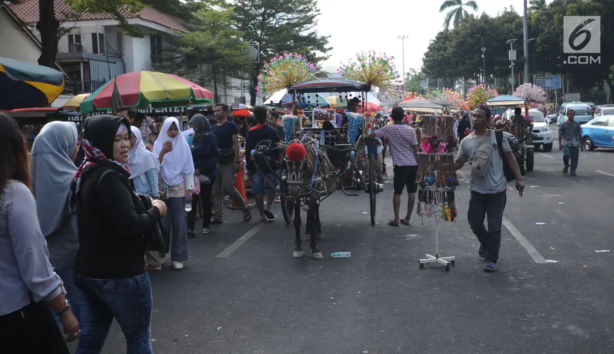 Delman hias menunggu pengunjung di sekitar Museum Fatahillah, Jakarta, Rabu (20/6). Libur lebaran 2018, sejumlah PKL memenuhi kawasan Kota Tua Jakarta, akibatnya jalan di sekitar Museum Fatahillah semrawut. (Liputan6.com/Helmi Fithriansyah)