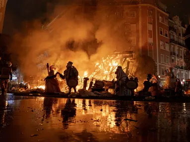 Falla terbakar selama festival Fallas tradisional di Valencia, Spanyol, Sabtu (19/3/2022). Fallas adalah struktur raksasa yang terbuat dari karton yang menggambarkan peristiwa dan kepribadian terkini di mana tokoh individu atau Ninot ditempatkan. (AP Photo/Alberto Saiz)