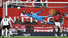 Penjaga gawang Manchester United, David De Gea (tengah), berhasil menghalau bola dari sundulan pemain Fulham dalam babak perempat final Piala FA 2022/2023, Minggu (19/3/2023) malam WIB. Berkat hasil ini, Manchester United pun berhak melenggang ke babak semifinal untuk menghadapi Brighton di Wembley. (AFP/Paul Ellis)