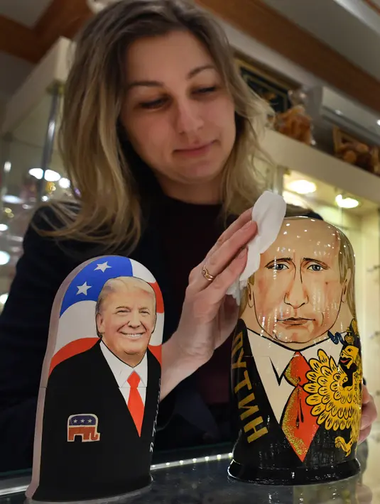 Seorang penjaga toko memoles Matryoshka berkarakter Presiden Vladimir Putin di Moskow, Rusia (16/1). Boneka Matryoshka ini konon idenya berasal dari Jepang dan sudah ada dan menjadi trade mark Russia sejak tahun 1890. (AFP/Alexander Nemenov)