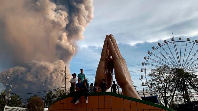 Sejumlah orang menyaksikan Gunung Api Taal erupsi di Tagaytay, Provinsi Cavite, Filipina, Minggu (12/1/2020). Ribuan orang yang tinggal di dekat gunung tersebut kemudian dievakuasi dari rumah mereka. (AP Photo/Bullit Marquez)