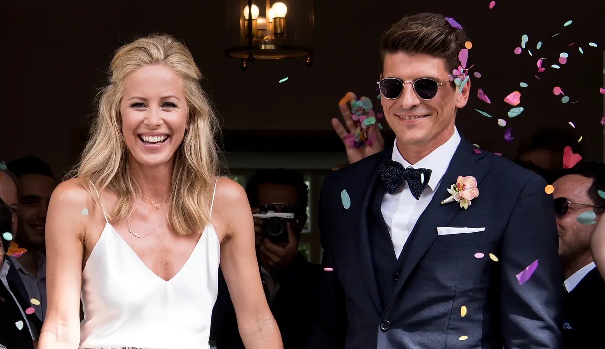 Senyum bahagia Mario Gomez (kanan) dan istrinya Carina Wanzung uasi menjalani pernikahan di Munich, Jerman, (22/7). Gomez menikahi Model Carina Wanzung, setelah berpisah dengan Silvia Meichel. (AFP PHOTO/ Sven Hoppe)
