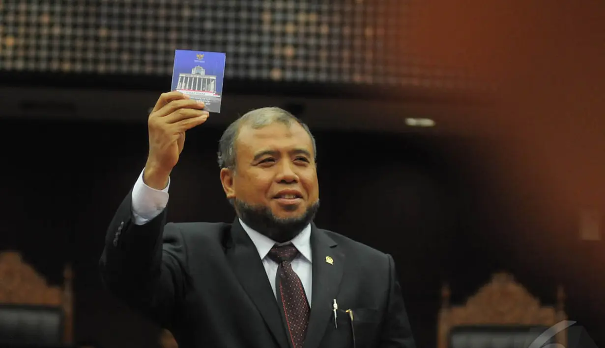 Hakim Konstitusi, Patrialis Akbar saat menunjukkan kertas suara dalam pemilihan Ketua dan Wakil Ketua MK di Gedung MK, Jakarta, Senin (12/1/2015). (Liputan6.com/Herman zakharia)