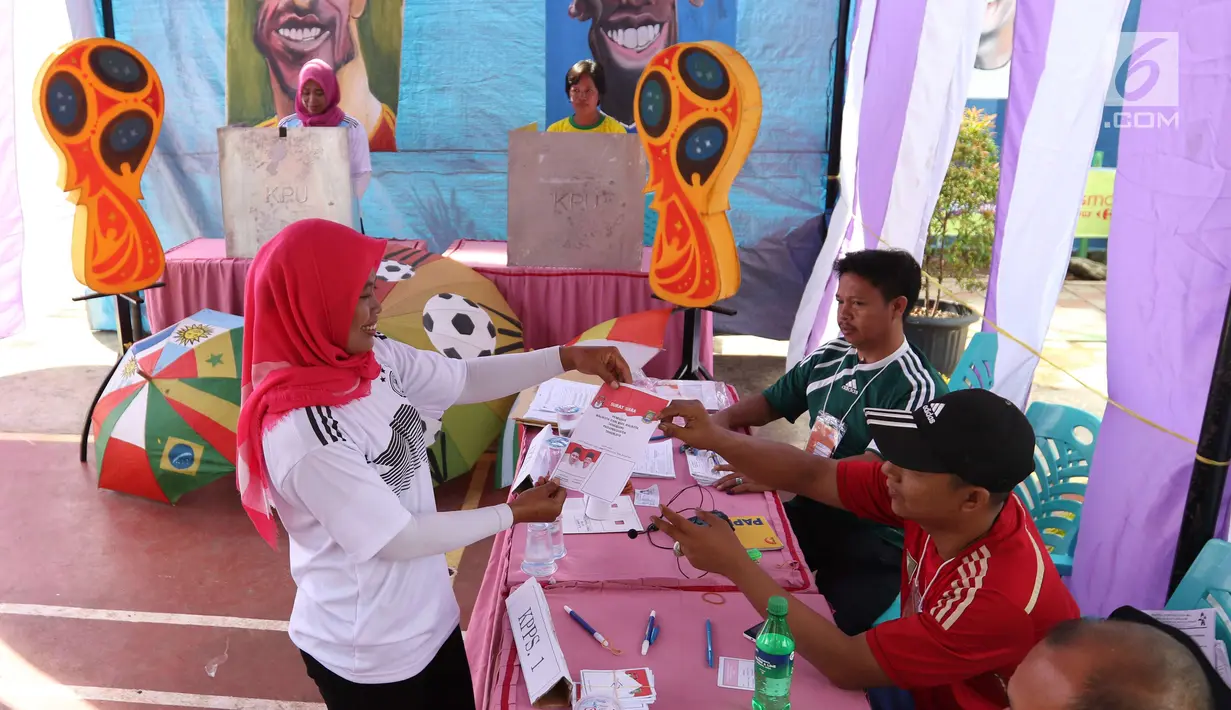 Seorang warga menggunakan hak politiknya dalam Pilkada Serentak 2018 di TPS 29 Gandasari, Kota Tangerang, Rabu (27/6). Di TPS ini warga yang memilih untuk Pilkada Kota Tangerang dapat merasakan sensasi Piala Dunia 2018 (Liputan6.com/Angga Yuniar)